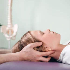 Chiropractor adjusting woman's neck on table.