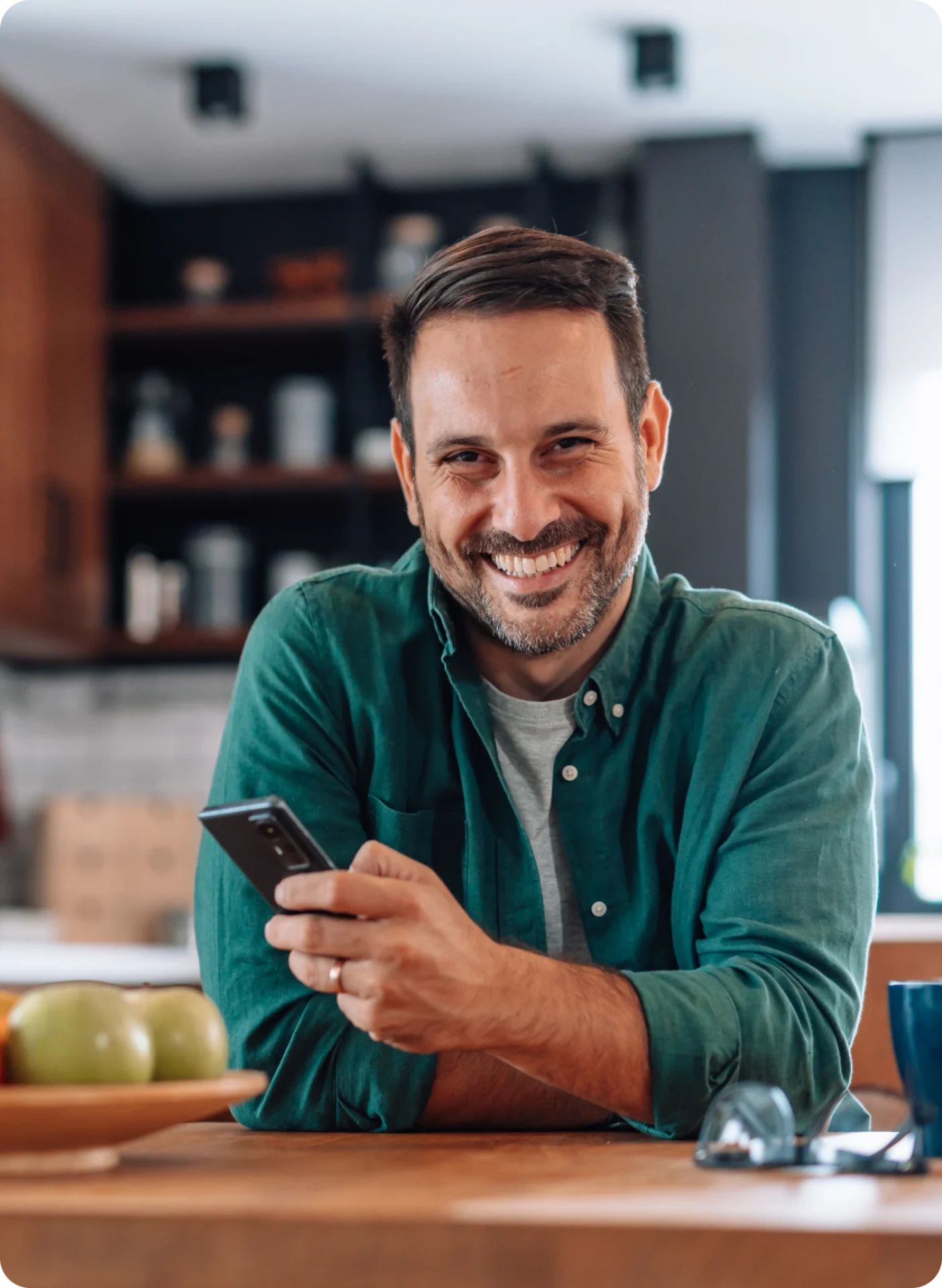 Man smiling while holding a smartphone.
