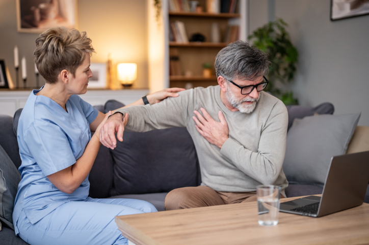 Nurse assisting man with shoulder pain.